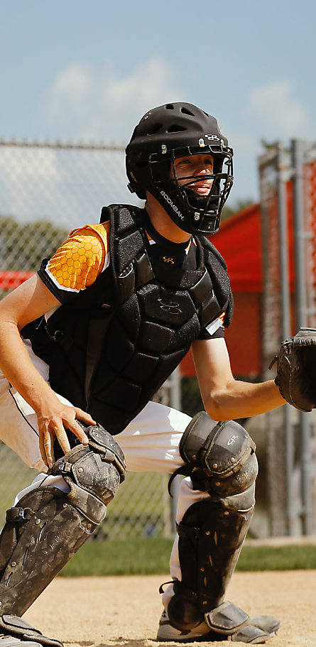 A baseball player in black catcher's gear
