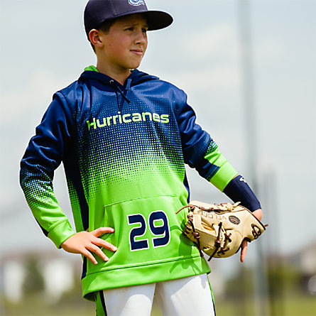 A young baseball player in a blue and green pullover