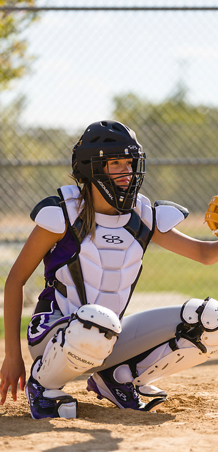 A bsoftball player in purple and white catcher's gear