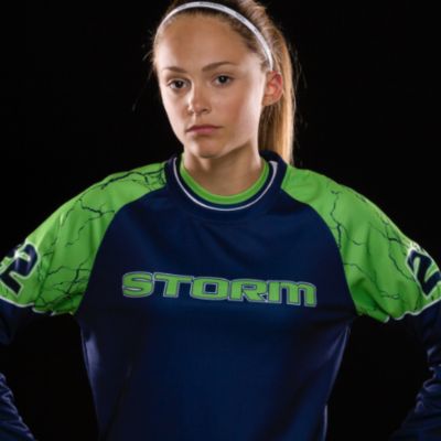 A girl in a green and blue softball jersey