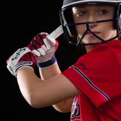 A softball player in a red jersey at bat