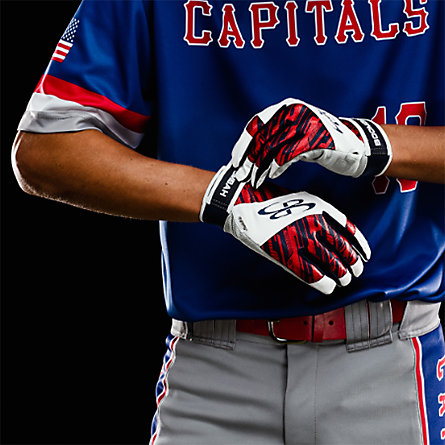 A baseball player putting on a pair of white, black and red batting gloves