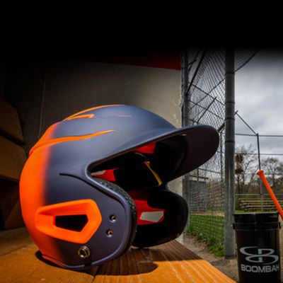 A navy and orange batting helmet in a dugout