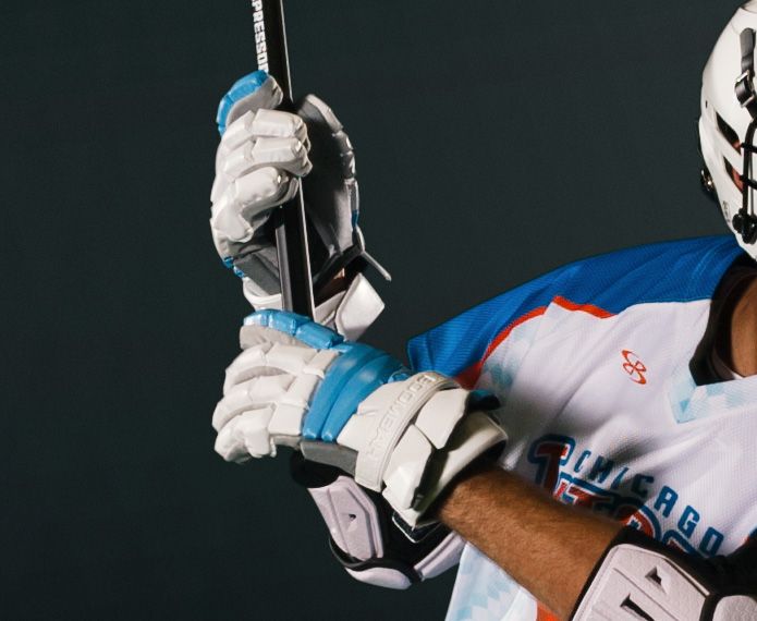 Male lacrosse player with white and blue gloves