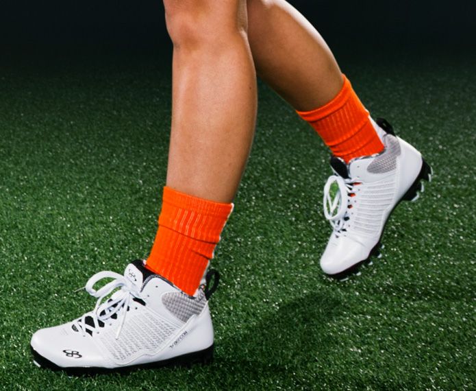 White women's cleats with orange socks